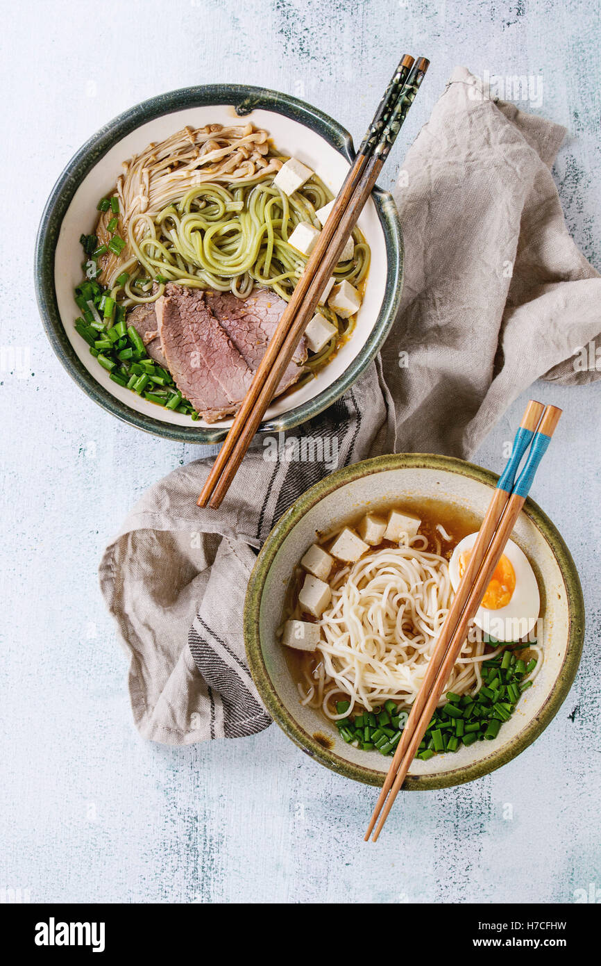 Two bowl of different asian style soups with green tea soba noodles