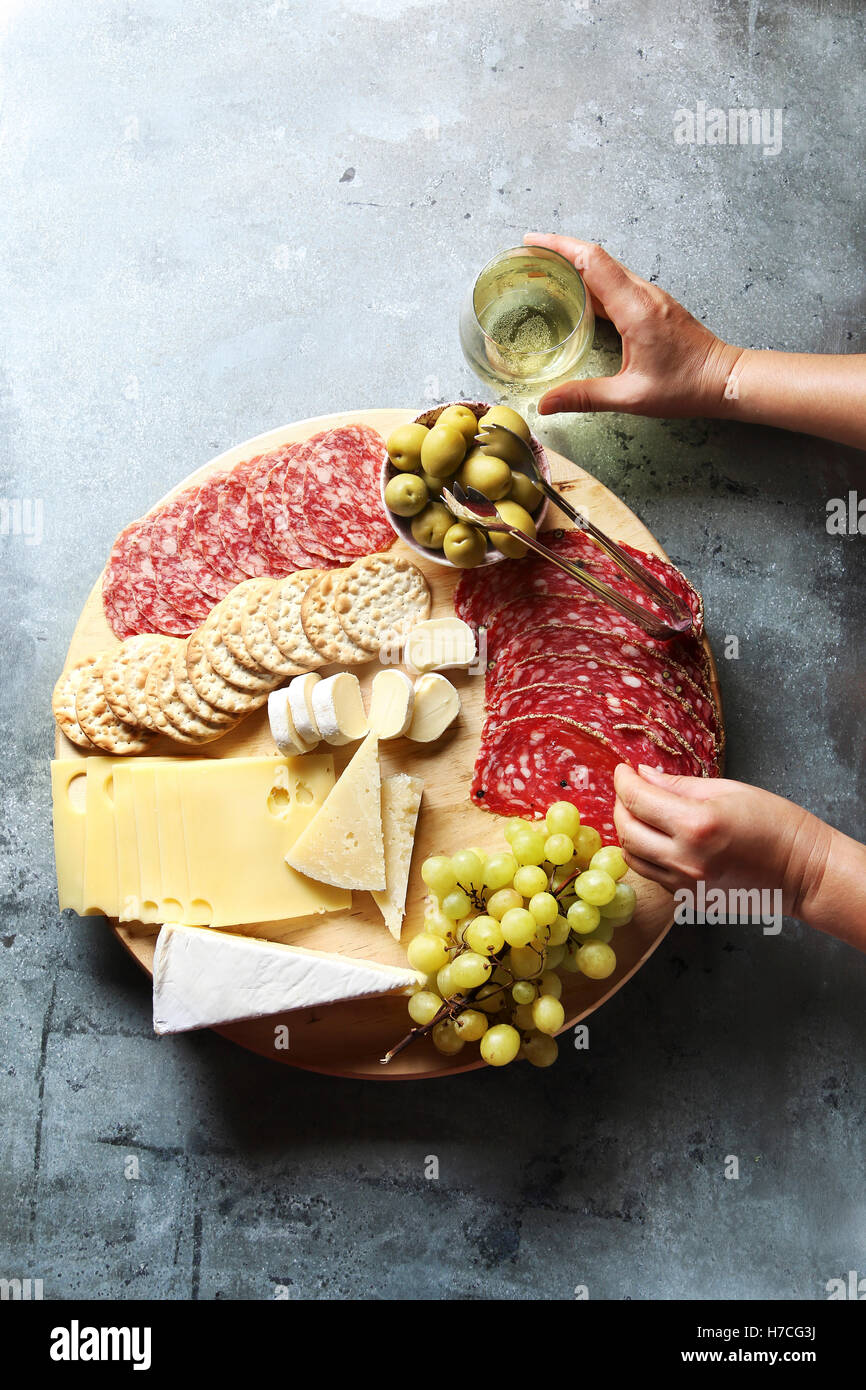 Cheese board with assorted sausages and salami, fresh fruit and various