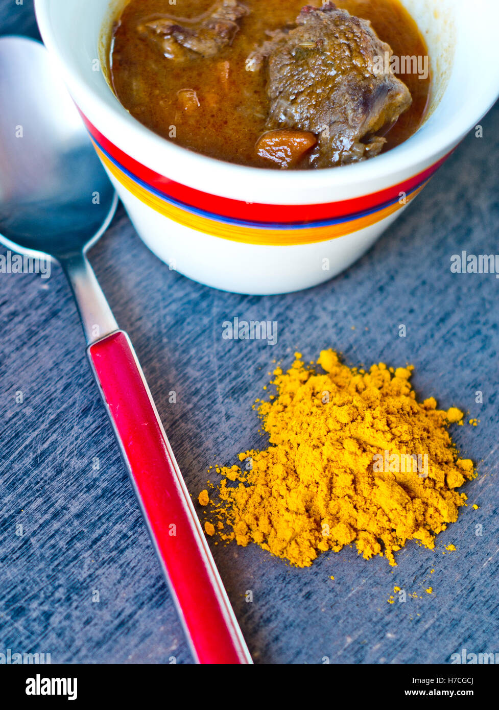 cup of tasty soup, hot and steaming with beef, vegetables, curry, turmeric and clove seeds Stock Photo