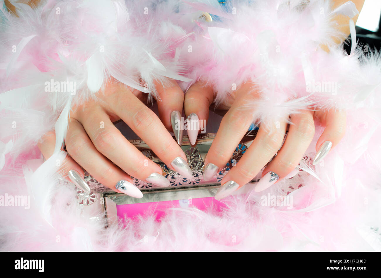 beautiful fingernails decorated with pink and pearl colors with rhinestones that reflect the light and create extraordinary effe Stock Photo