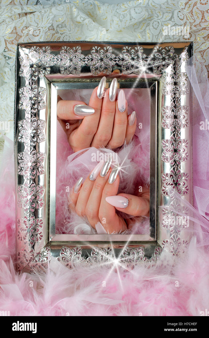 beautiful fingernails decorated with pink and pearl colors with rhinestones that reflect the light and create extraordinary effe Stock Photo