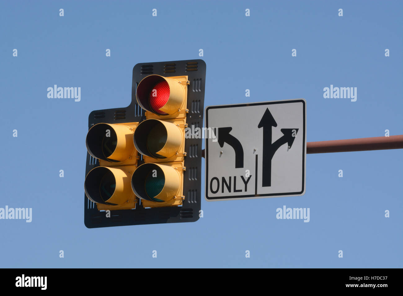 Red traffic light signal and sign for left turn only and left or straight ahead lanes Stock Photo