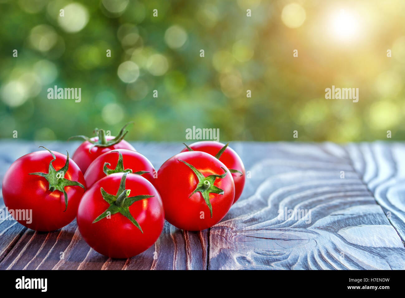 cherry tomatoes  on wooden board outdoors Stock Photo