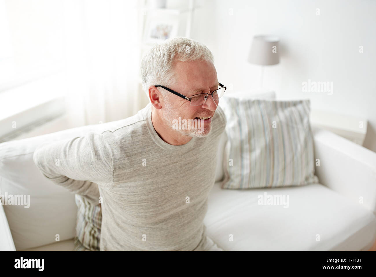 unhappy senior man suffering from backache at home Stock Photo - Alamy