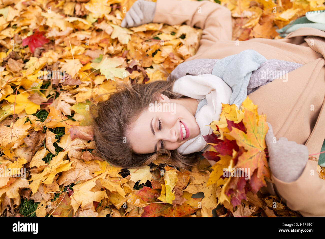 beautiful happy woman lying on autumn leaves Stock Photo - Alamy