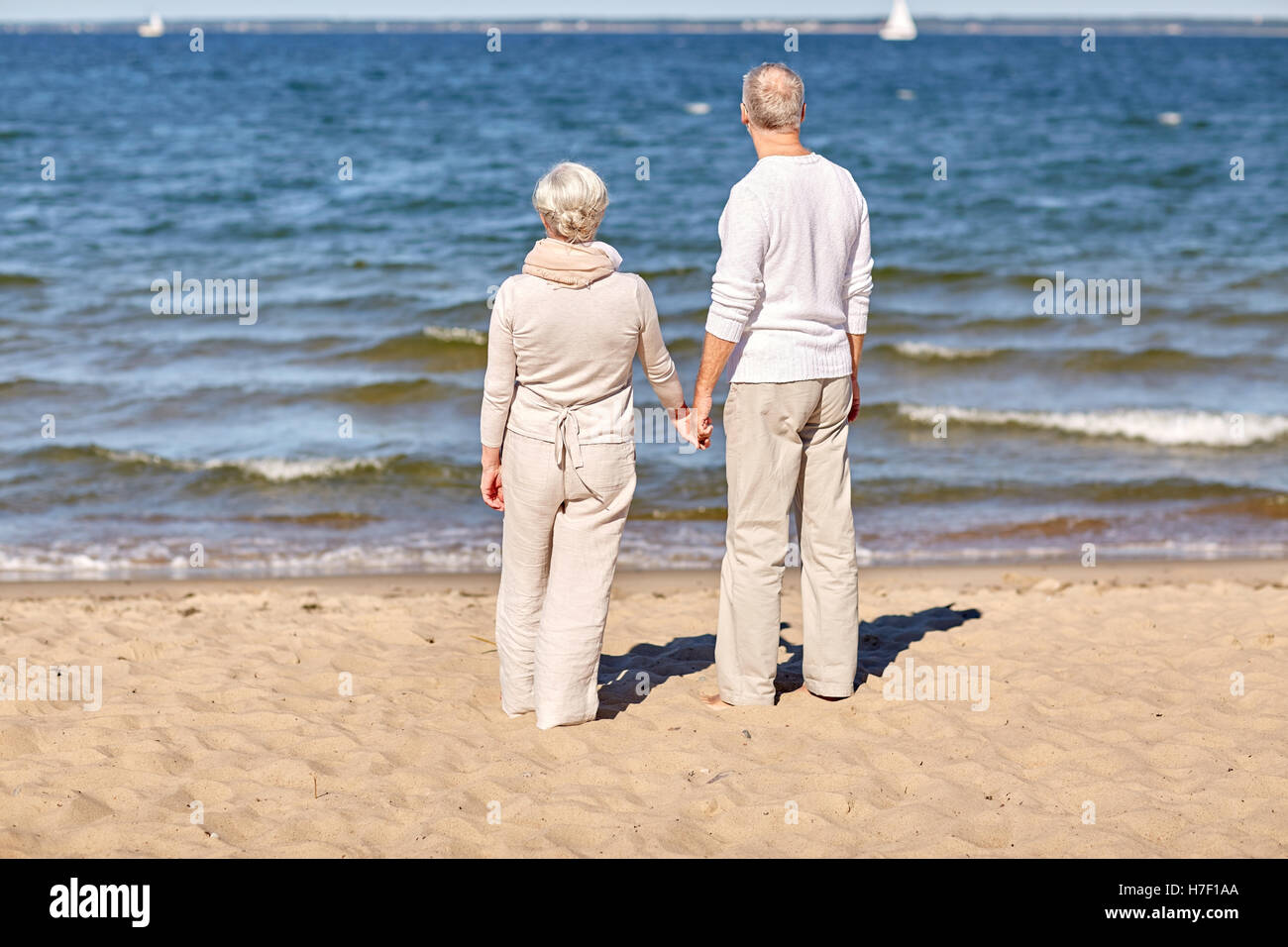 happy senior couple holding hands summer beach Stock Photo - Alamy