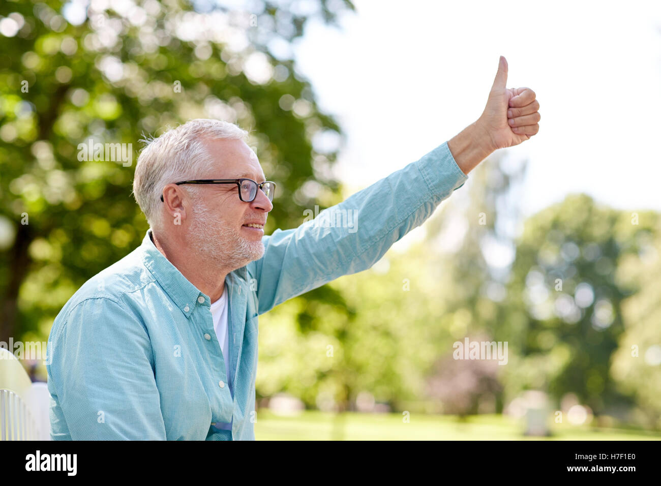 happy senior man showing thumbs up at summer park Stock Photo - Alamy