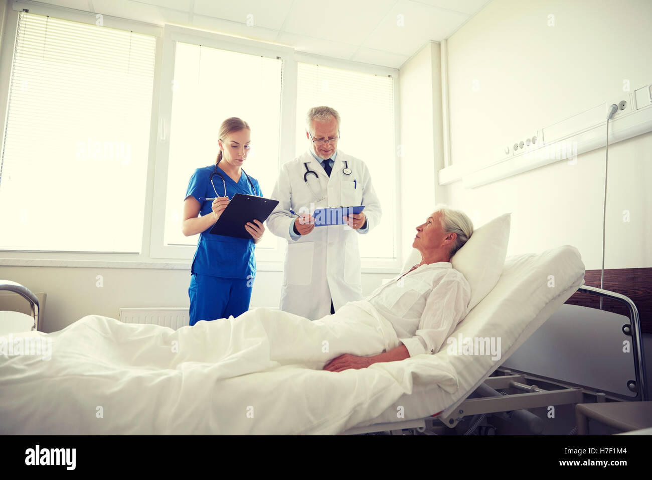 doctor and nurse visiting senior woman at hospital Stock Photo - Alamy