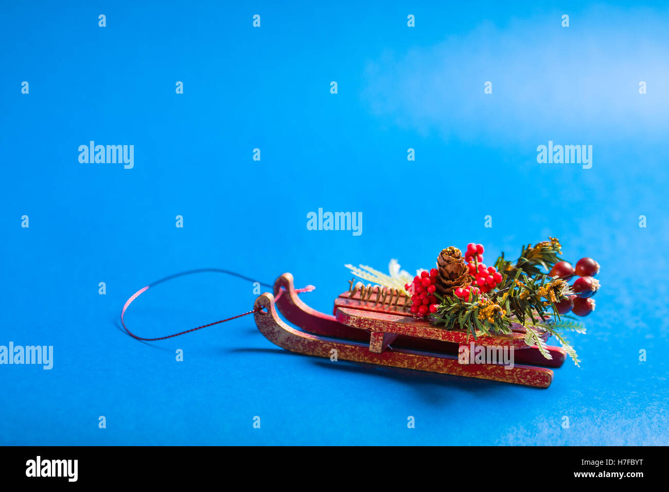 Christmas card with decorative sledge standing on blue background. Stock Photo