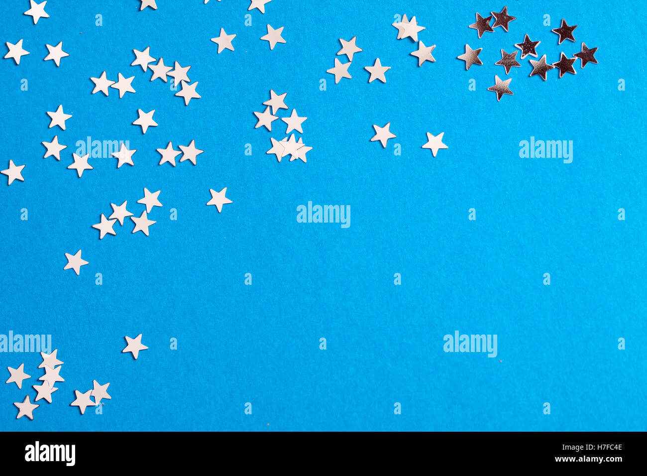 Frame of scatters little silver stars on blue background. Stock Photo