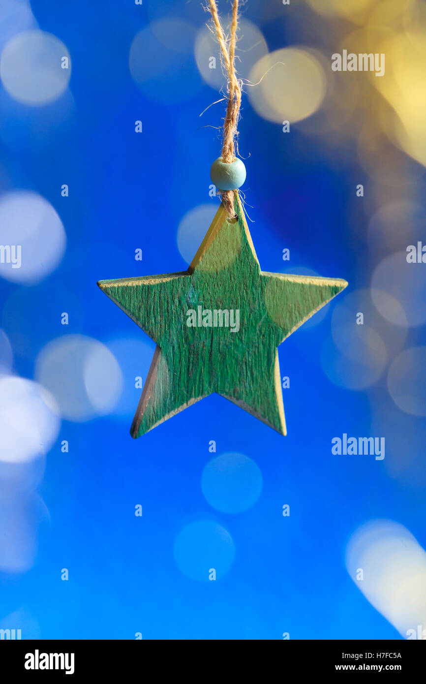 Greeting card with wooden green star and blurred glitter glow. Stock Photo