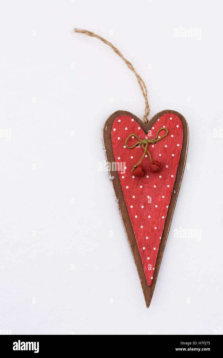 A red decorative wooden heart on the snow. Stock Photo