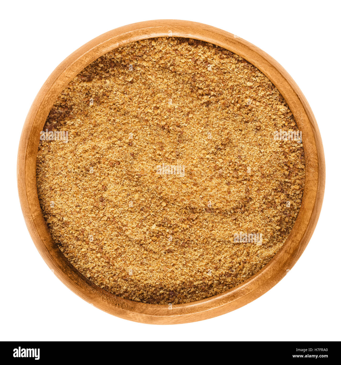 Dark coconut blossom sugar in a wooden bowl on white background. Raw brown unrefined sugar from the coconut palm. Stock Photo