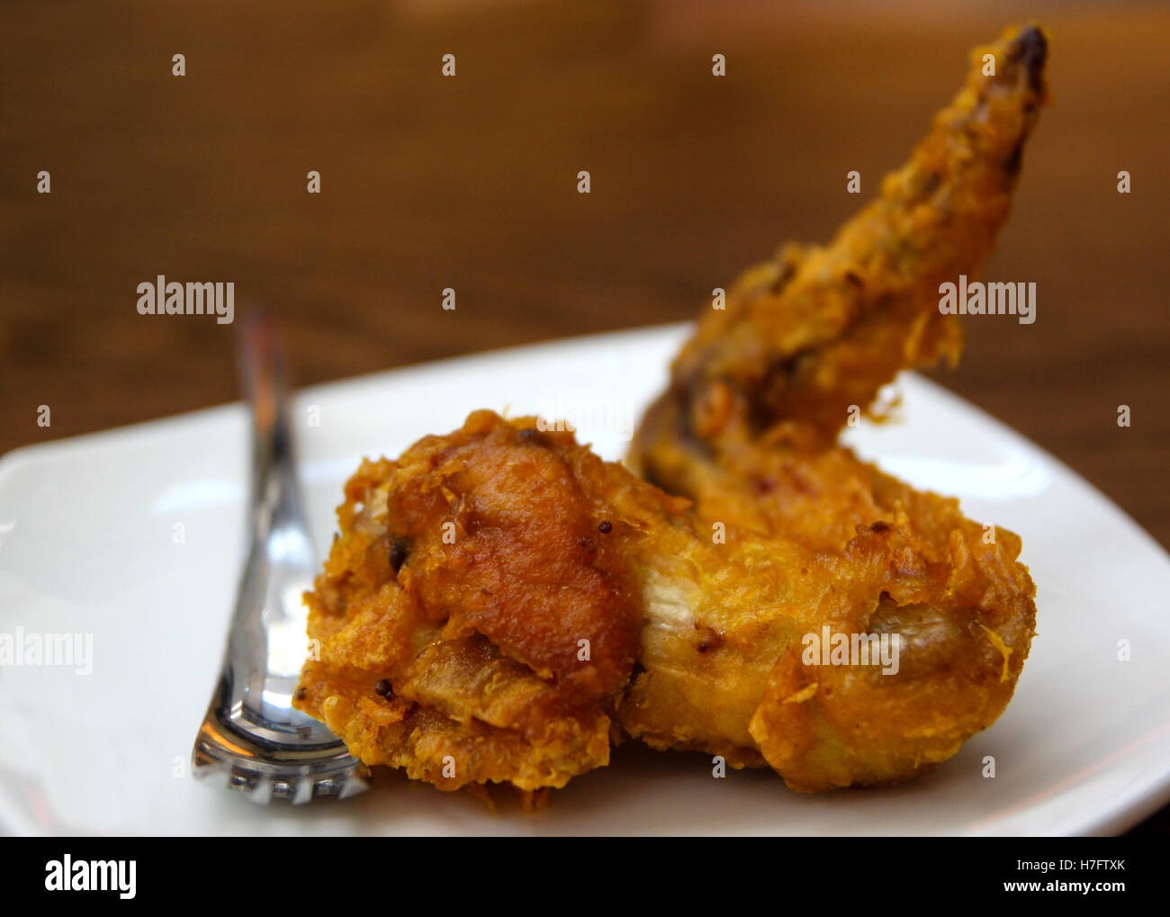 Singapore style crispy, golden brown chicken wing deep fried to perfection, with copy space. Stock Photo