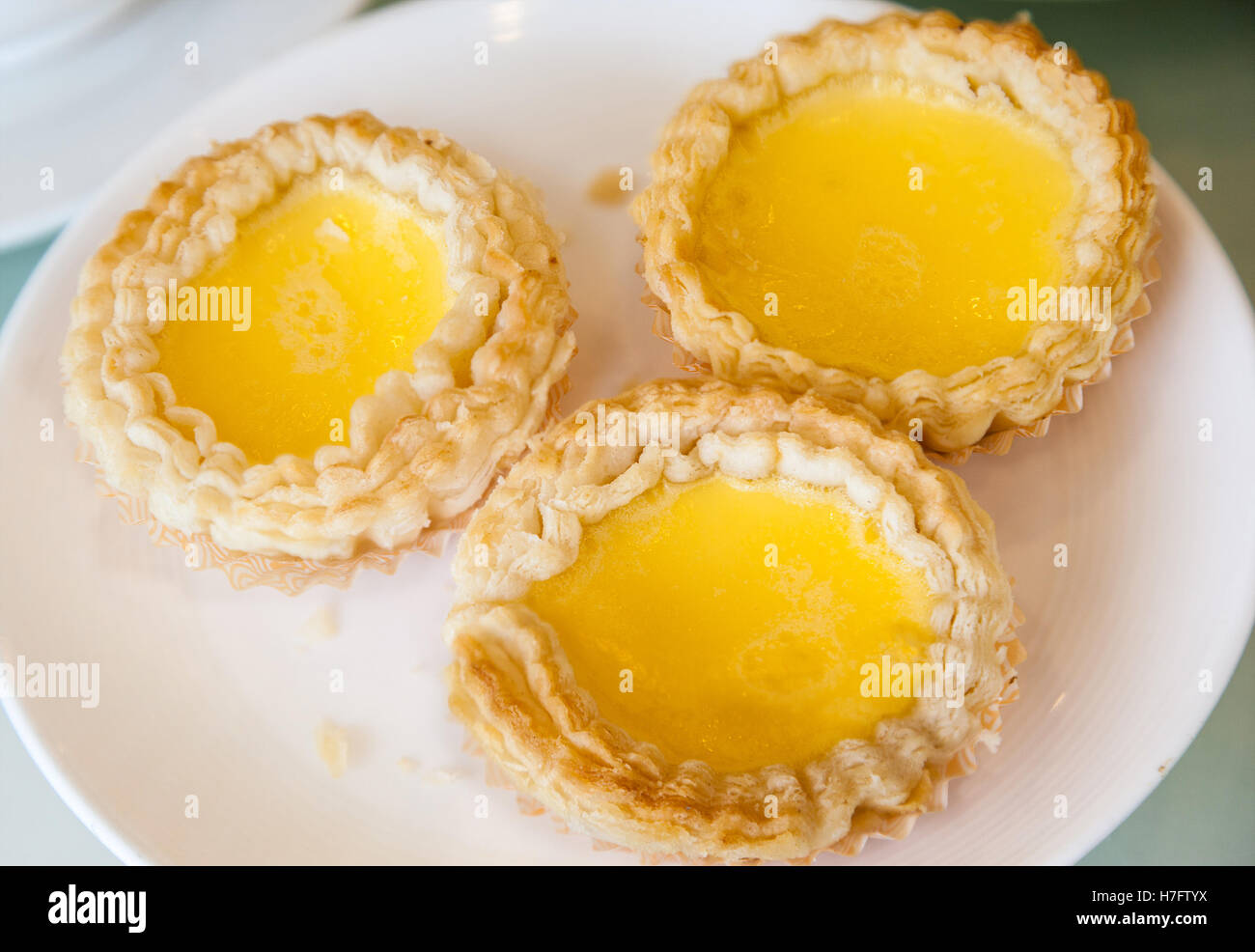 Baked egg tart dim sum is a popular dessert in Cantonese restaurants in Hong Kong and southern China. Stock Photo