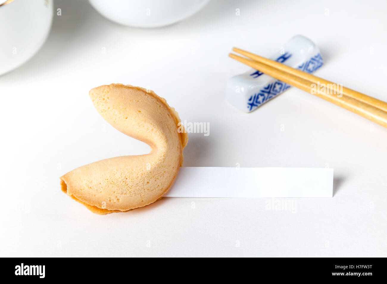 Fortune cookie with blank slip and Chinese chopsticks and cups in