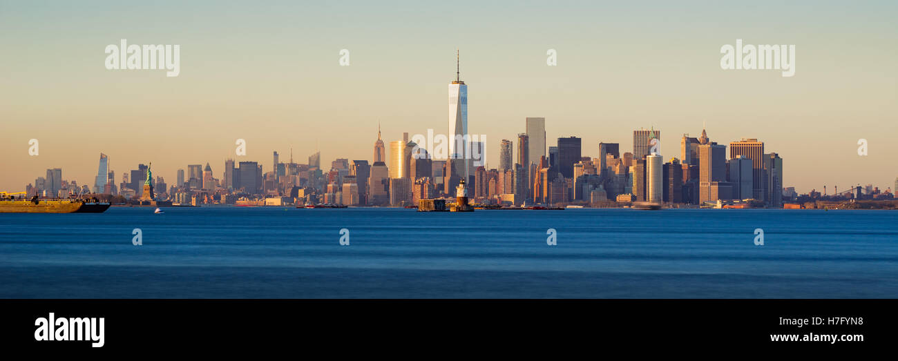 Panoramic Sunset of Lower Manhattan and New York City Harbor with Financial District skyscrapers Stock Photo