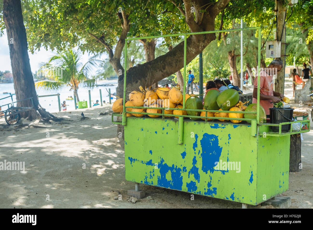Stall selling fresh coconut juice and sliced pineapples by public beach
