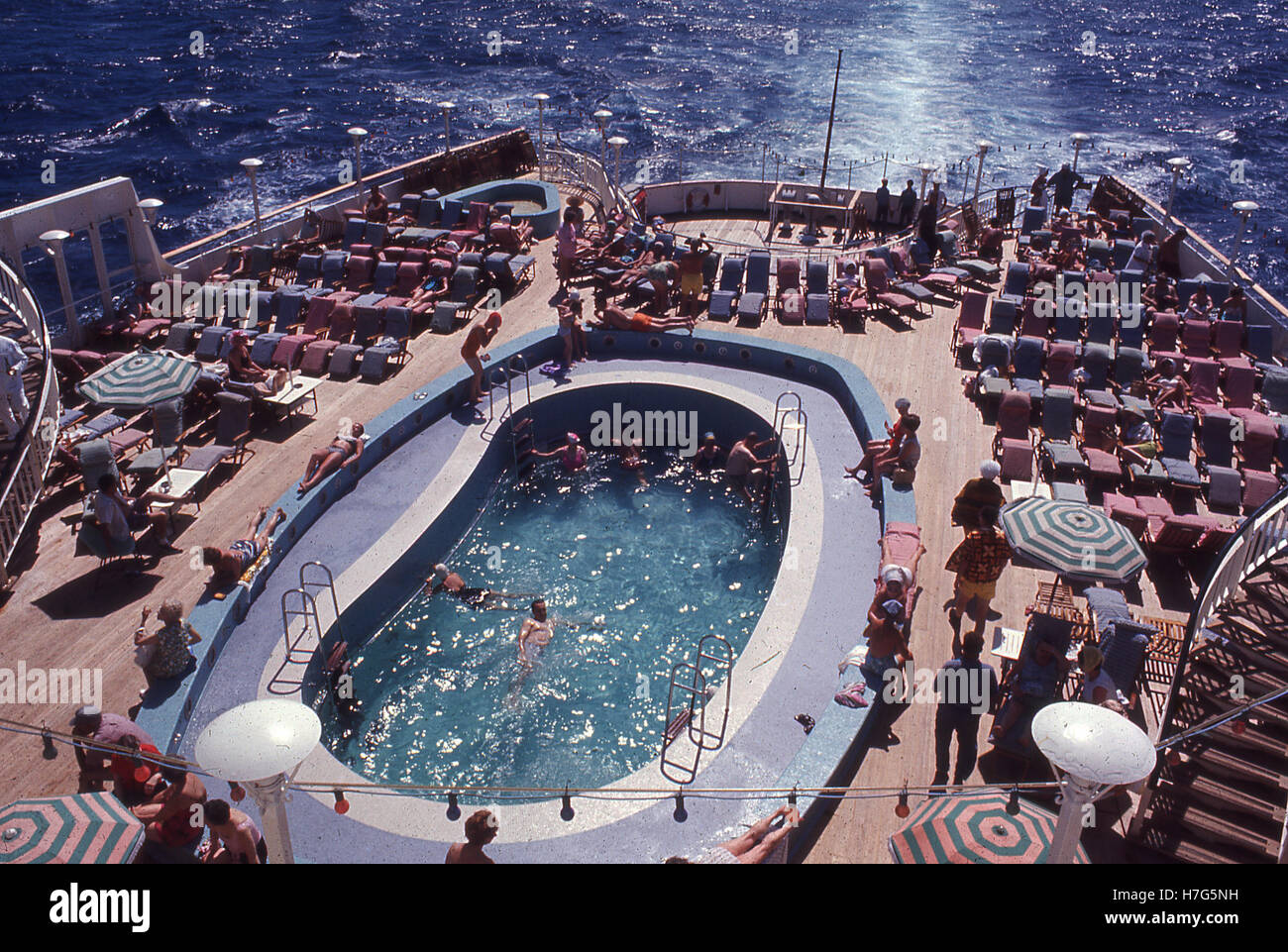 Cruising in the 1960s, picture shows a swimming pool and deck chairs on a cruise ship of this era. Stock Photo