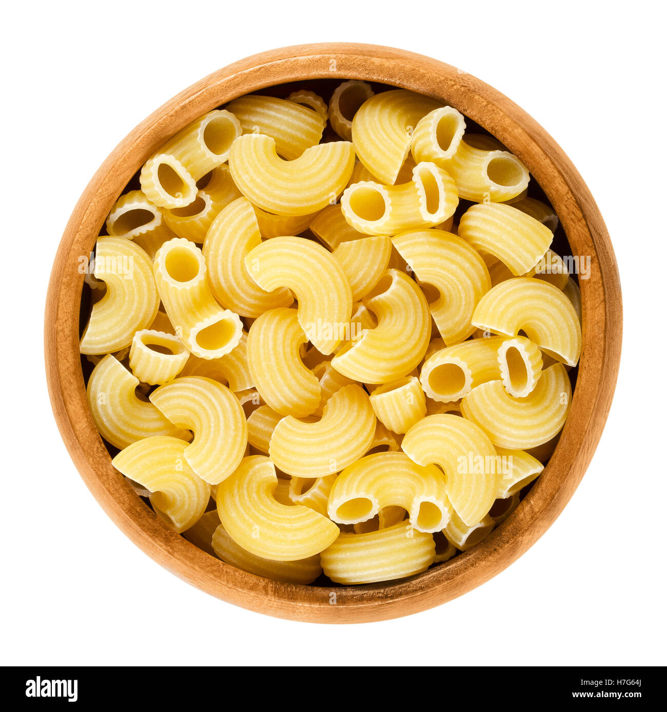 Chifferi pasta in wooden bowl. Bent tubes, short-cut and wide macaroni. Italian noodles prepared with eggs. Stock Photo