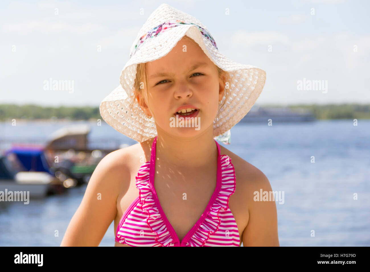 Cute girl in pink swimsuit and white hat Stock Photo