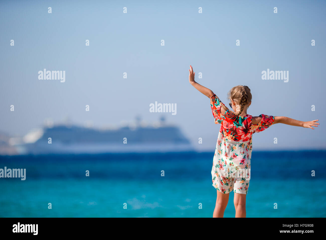 Adorable little girl at beach background big lainer in Greece Stock Photo