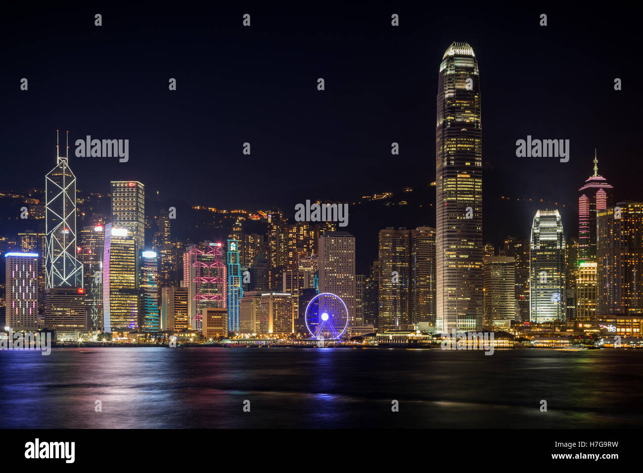 Hong Kong Island's skyline over Victoria Harbour with lit modern skyscrapers at night in Hong Kong. Viewed from Tsim Sha Tsui. Stock Photo