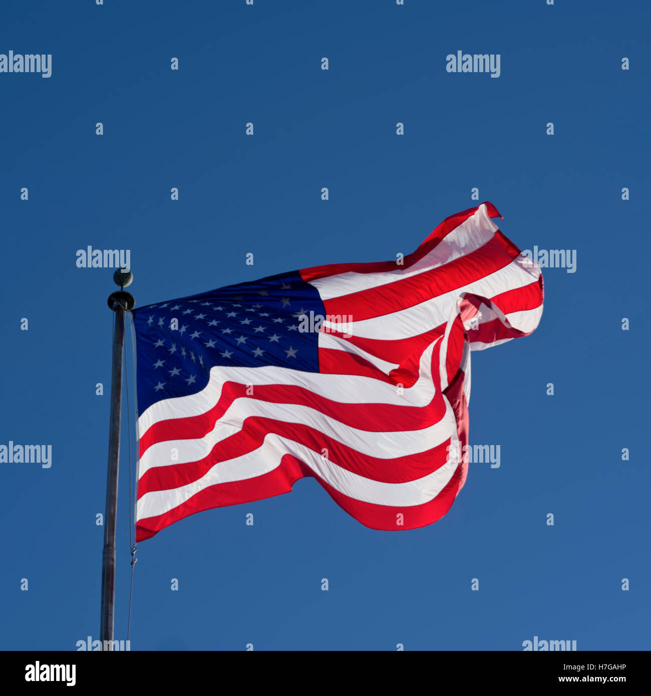 American flag on flagpole blowing in wind Stock Photo - Alamy