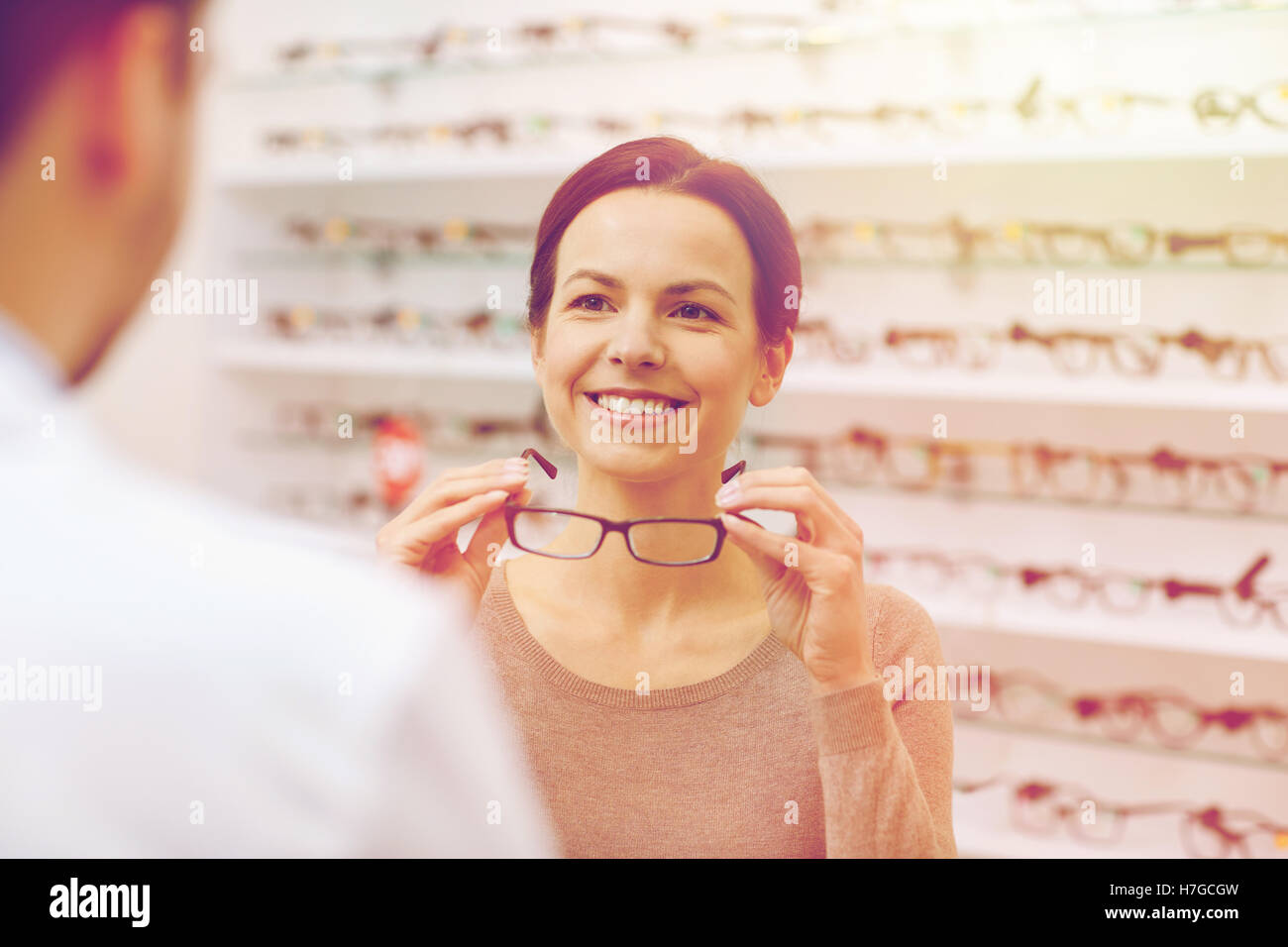 woman showing glasses to optician at optics store Stock Photo