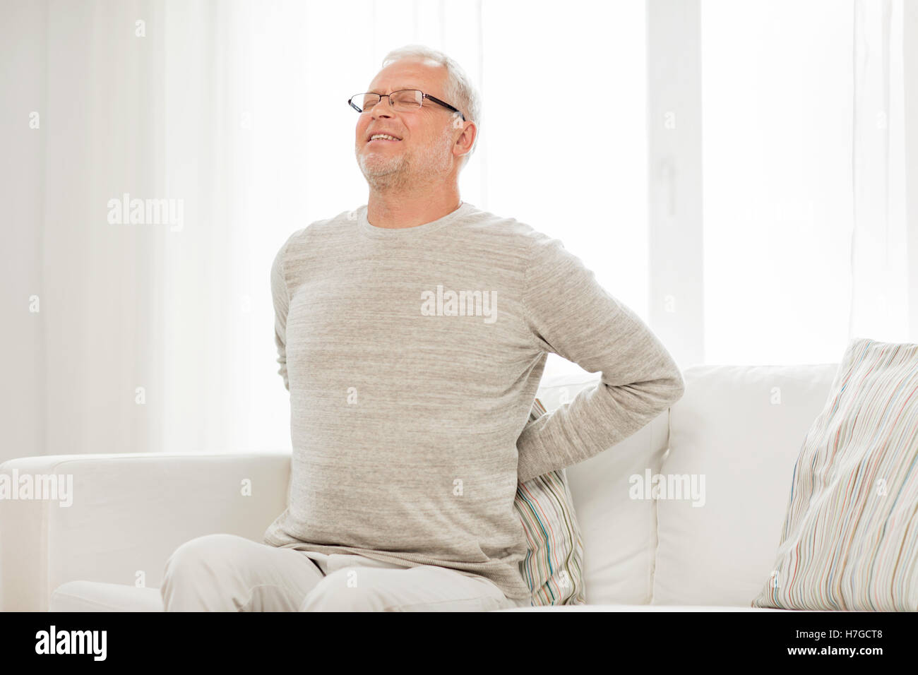 unhappy senior man suffering from backache at home Stock Photo - Alamy