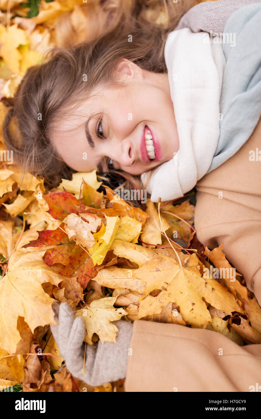 beautiful happy woman lying on autumn leaves Stock Photo - Alamy