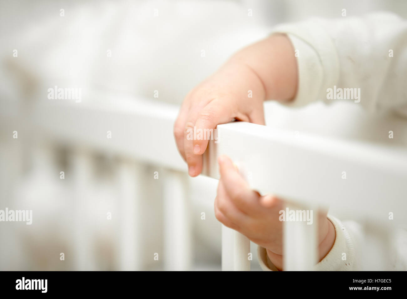 Infant tiny hands in the crib Stock Photo
