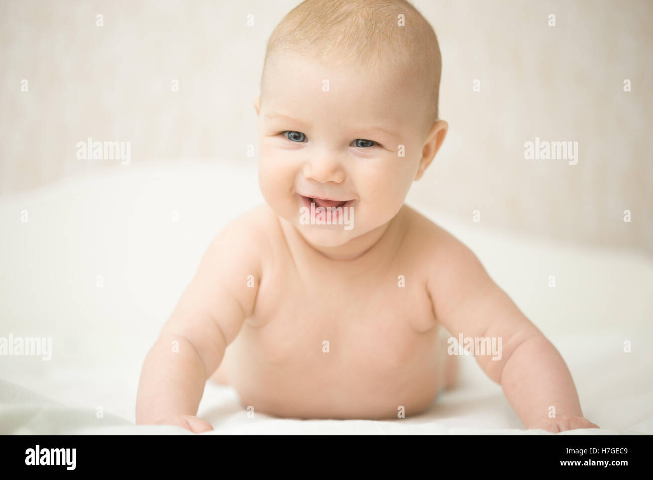 Portrait of a beautiful expressive laughing baby, holds head up Stock Photo
