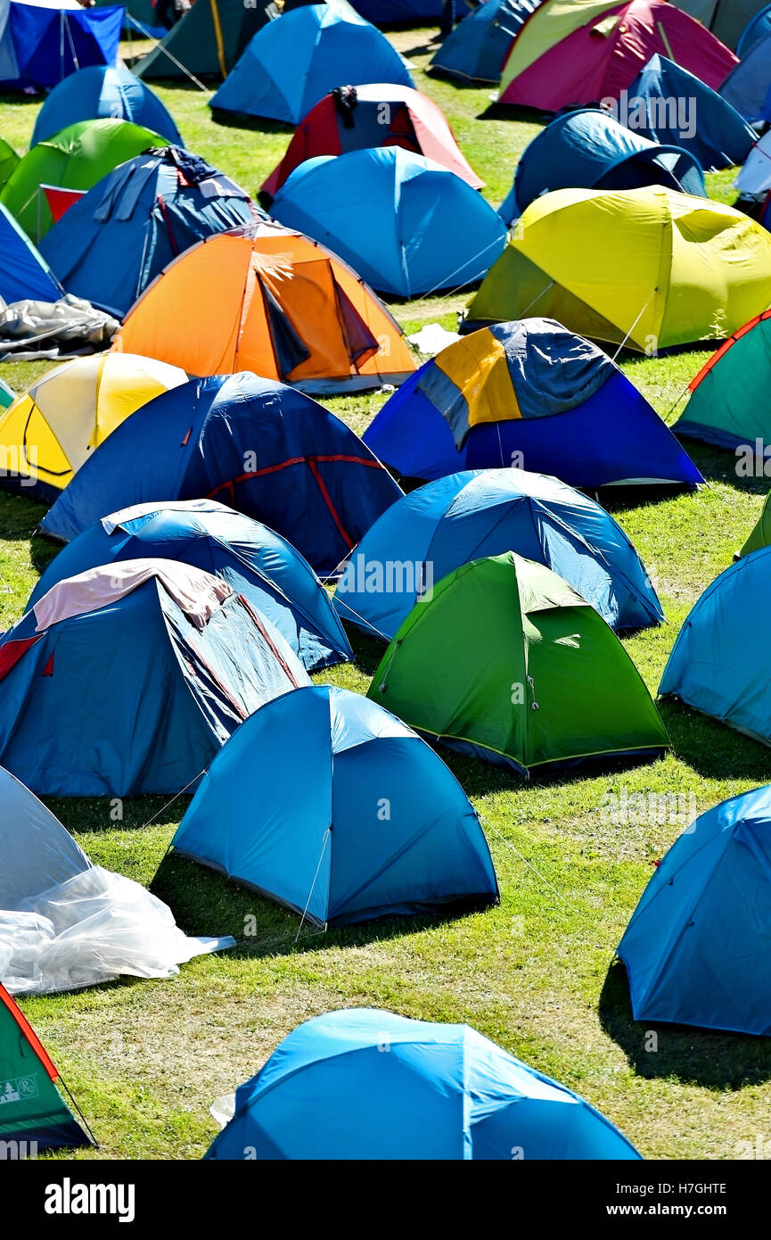 Lots of colorful tents on a meadow in a summer day during music festival Stock Photo