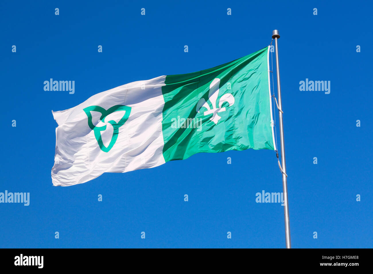 A flag with the Ontario and Québec logos in front of a blue sky in Hawkesbury, Ontario, Canada. Stock Photo