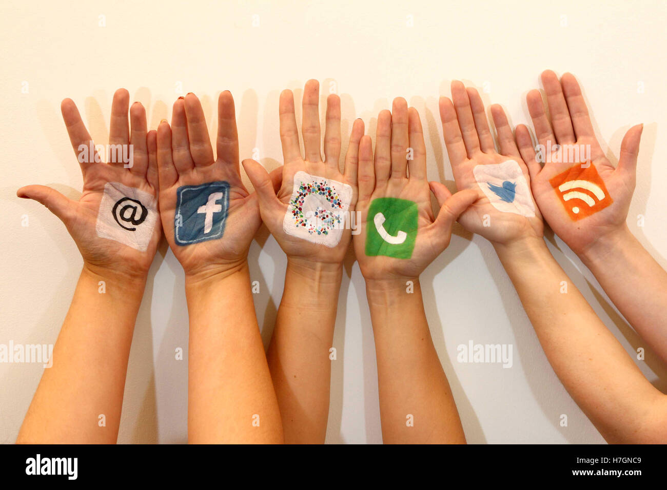 Hands together with social media logos Stock Photo - Alamy