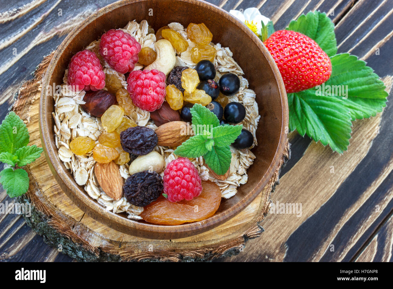 muesli and fresh berries, raisins and nutson a wooden table Stock Photo