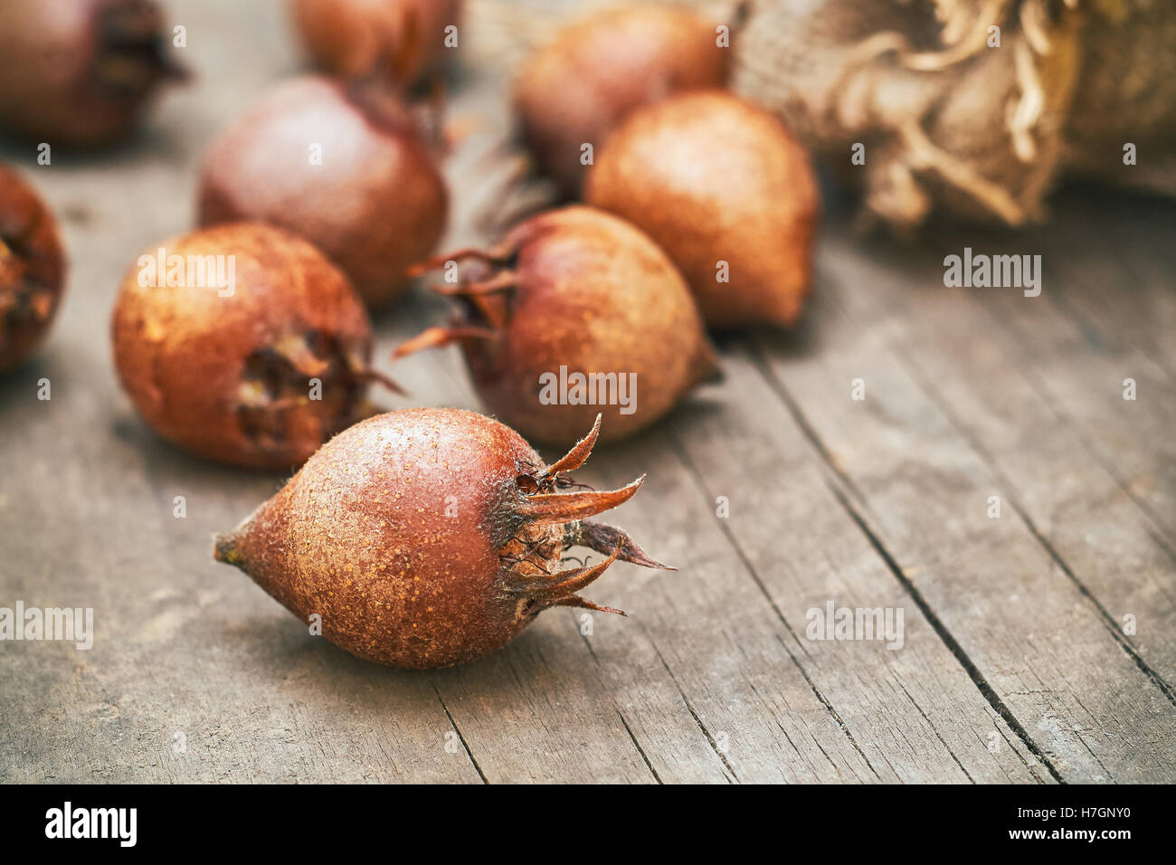 Common medlar fruit (mispel) on grey rustic wooden background. Copy space Stock Photo
