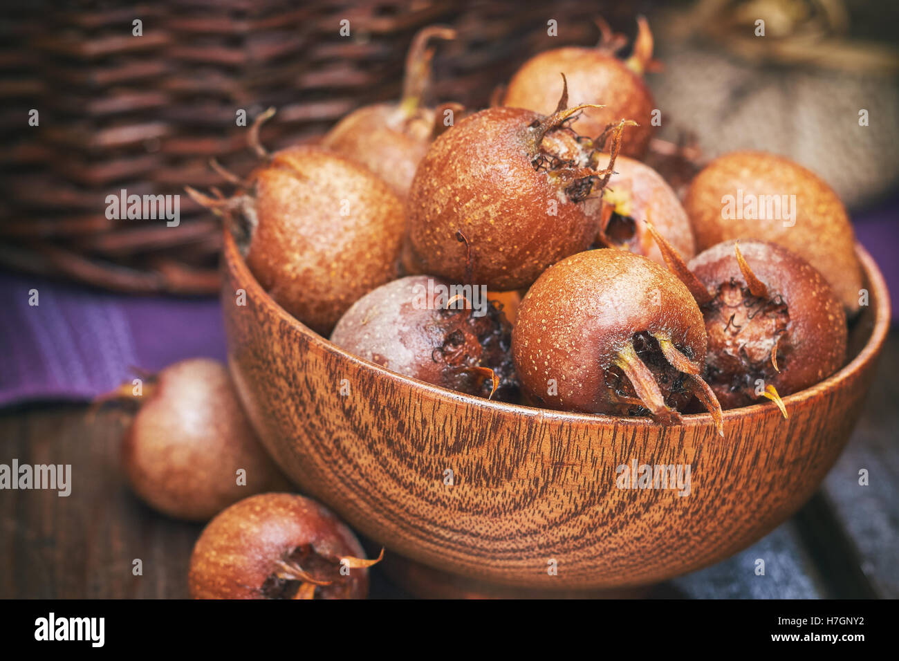 Common medlar fruit (mispel) in wooden bowl Stock Photo