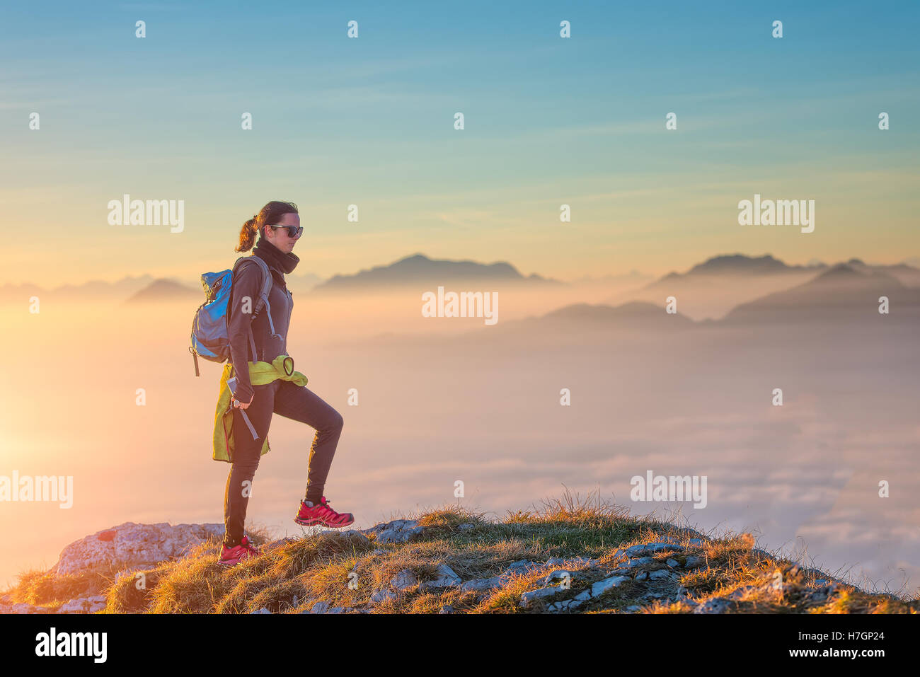 Hiking on mountain ridge in the sea of clouds. A girl alone Stock Photo ...