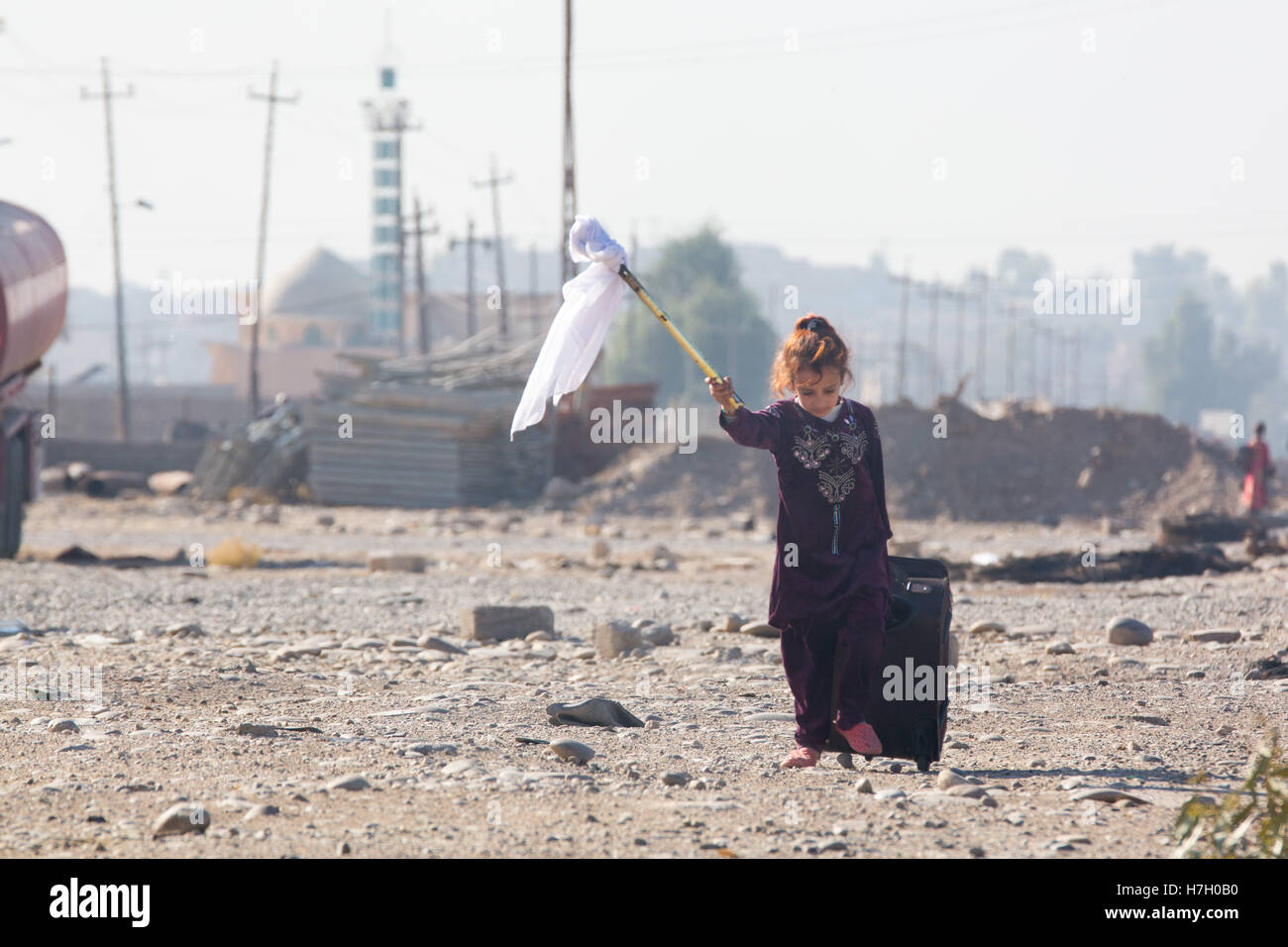 Mosul, Nineveh, Iraq. 4th Nov, 2016. Headline: Civilians Displaced as Drive to Clear Mosul of ISIS intensifies.Caption: A young Iraqi girl walks alongside a road waving a white flag as her family flees their home on the outskirts of Mosul. Thousands of civilians are fleeing the city which has been under harsh iSIS rule for more than two years. Photog: Nish Nalbandian.City: Mosul.Country: Iraq.Category: New.Date: 20161104 © Nish Nalbandian/ZUMA Wire/Alamy Live News Stock Photo