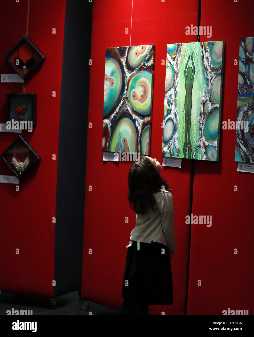 Frankfurt, Germany. 5th Nov, 2016. A girl looks at paintings at an art event for Romanian artists living in Frankfurt, during the Intercultural Week in Frankfurt, Germany, on Nov. 5, 2016. The Intercultural Week was held here from Oct. 29 to Nov. 12. © Luo Huanhuan/Xinhua/Alamy Live News Stock Photo