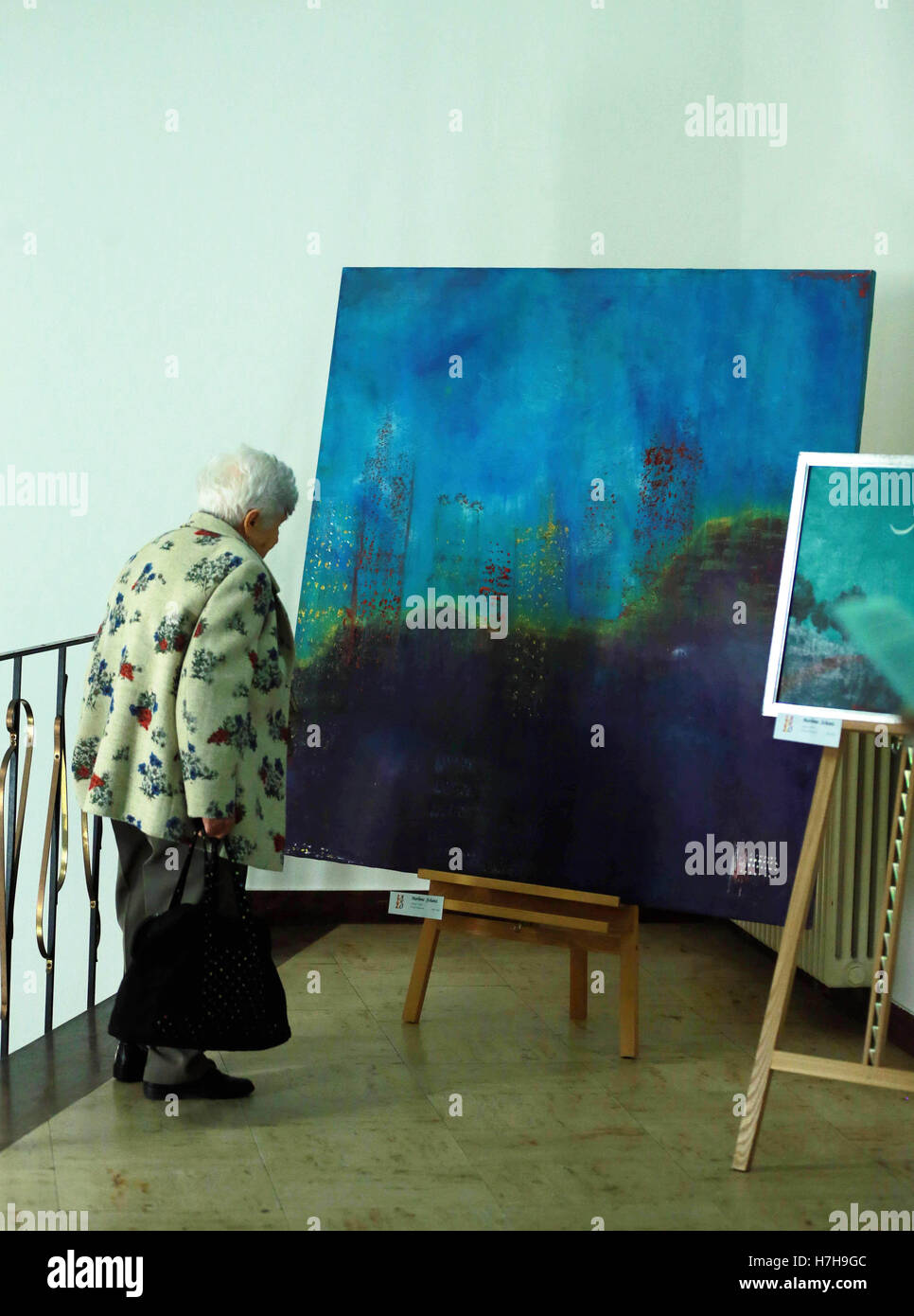 Frankfurt, Germany. 5th Nov, 2016. An old woman looks at paintings at an art event for Romanian artists living in Frankfurt, during the Intercultural Week in Frankfurt, Germany, on Nov. 5, 2016. The Intercultural Week was held here from Oct. 29 to Nov. 12. © Luo Huanhuan/Xinhua/Alamy Live News Stock Photo