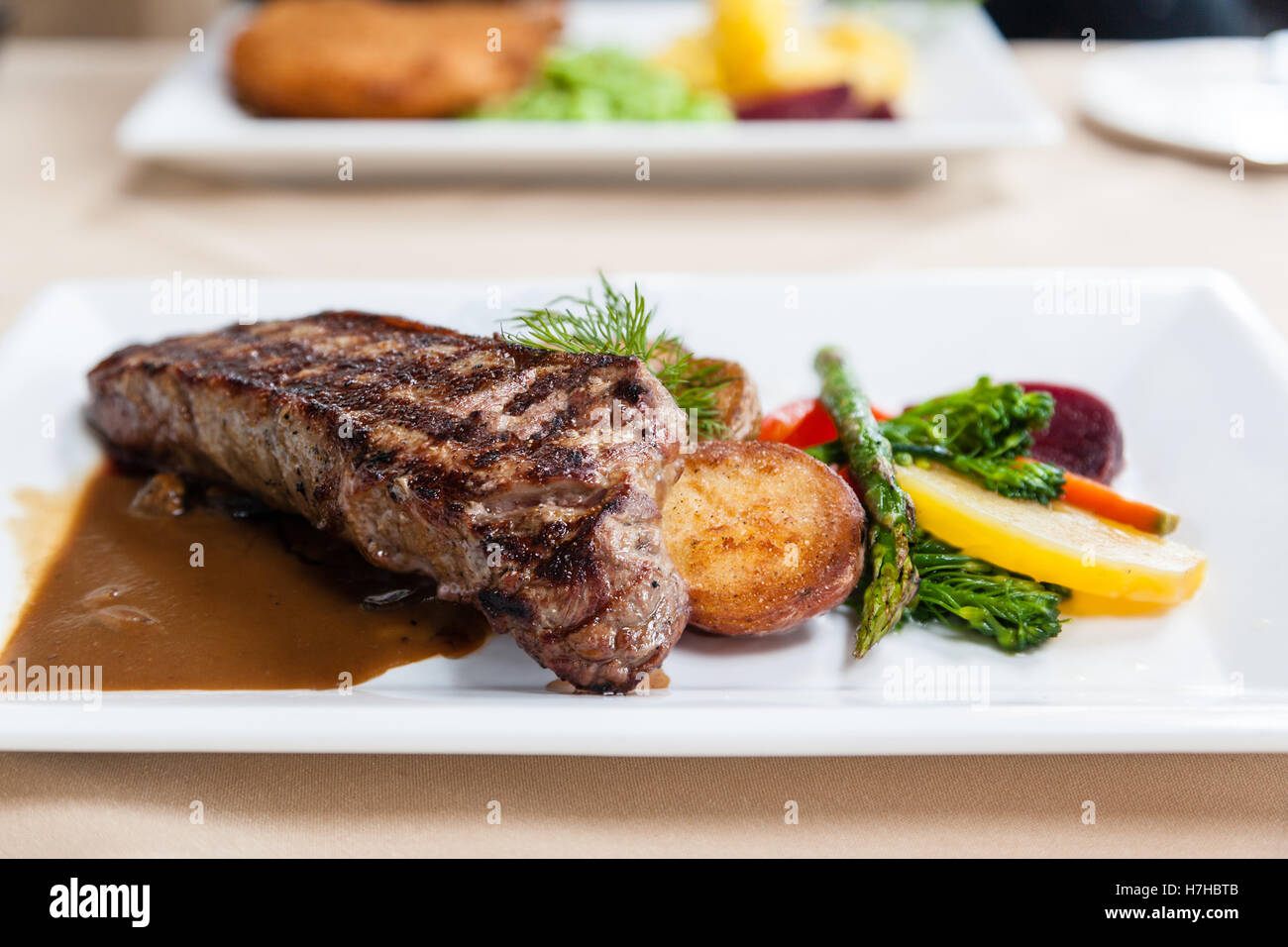 Grilled juicy New York strip loin beef steak served with potatoes