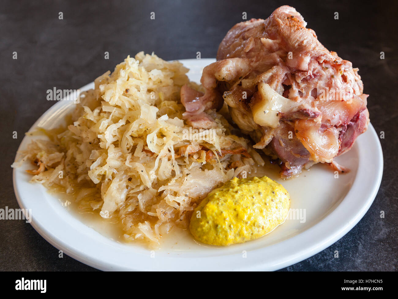 Traditional German ham hock or pork knuckle served with sauerkraut. Stock Photo