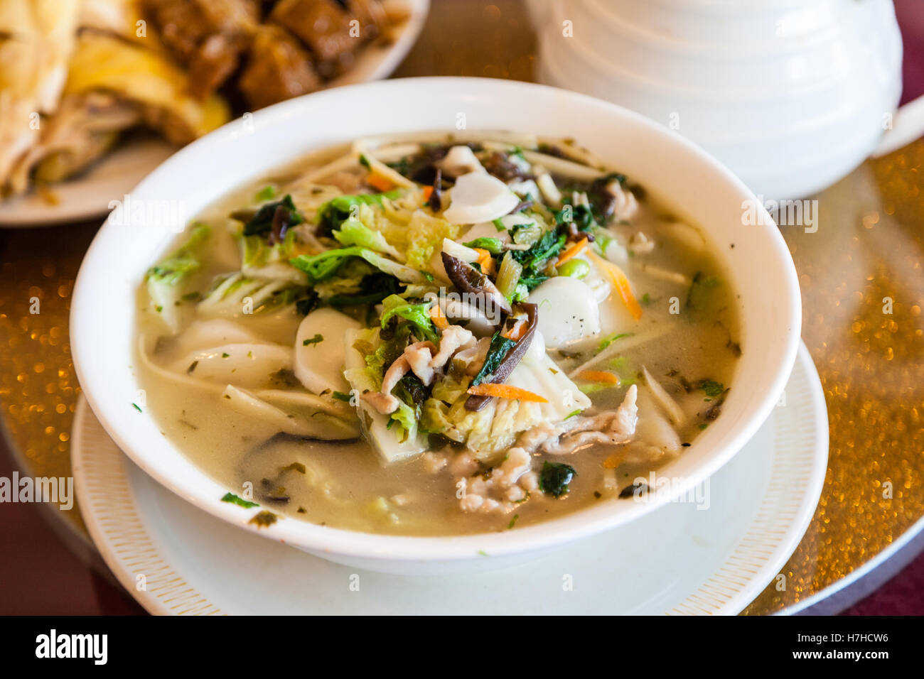 Traditional Chinese rice cake in broth with cabbage, mushroom, carrots and pork. Stock Photo