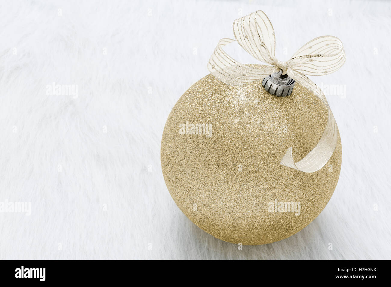 One beautiful, fancy,  perfect, sparkly, shiny, gold glitter Christmas ornament on horizontal white background Stock Photo