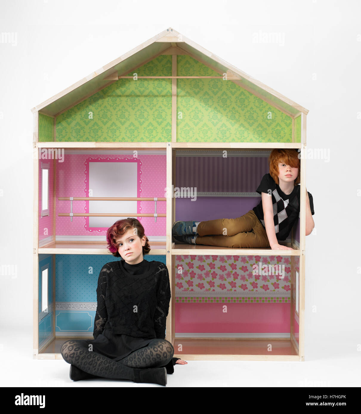 Teen girl and school boy with a giant doll house Stock Photo