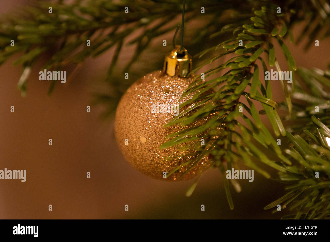 A gold coloured bauble hanging on a Christmas tree Stock Photo Alamy