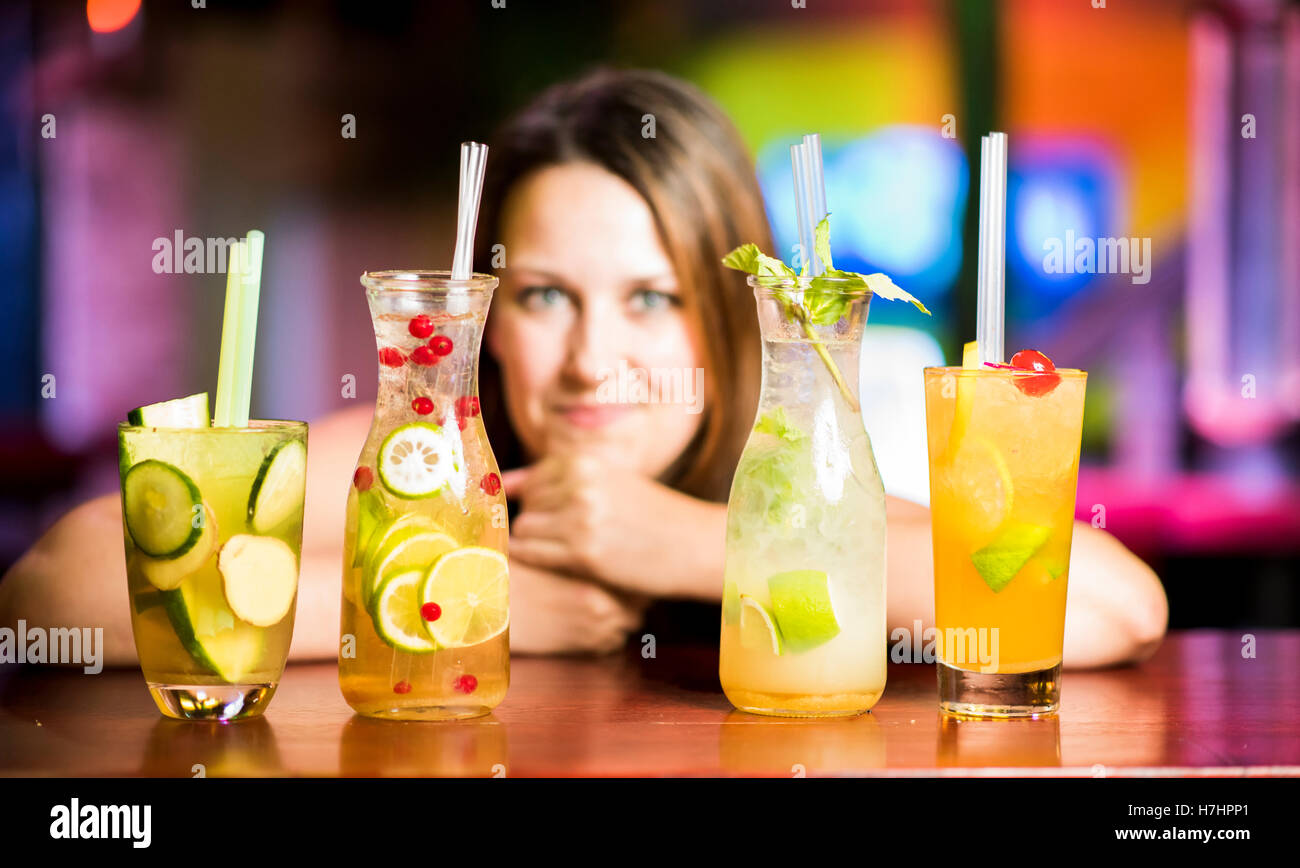 Cocktails with woman leaned against table, Stuttgart, Baden-Württemberg, Germany Stock Photo